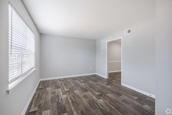 A room with a window and wooden flooring.